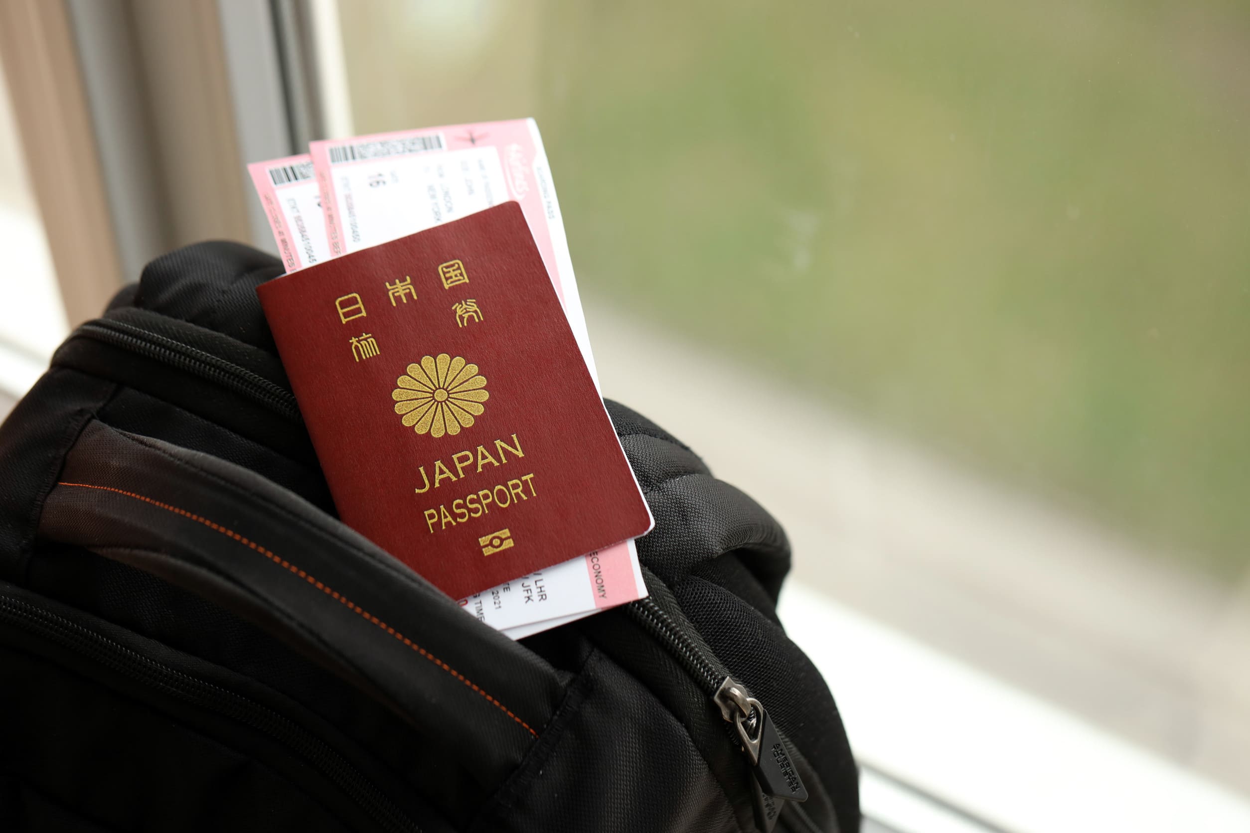 Japan Passport With Airline Tickets On Touristic Backpack Close Japan Passport With Airline Tickets On Touristic Backpack Close